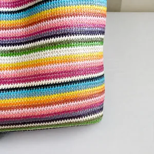 Detailansicht der bunten Regenbogenstreifen auf einer handgefertigten Strohtasche für Sommer