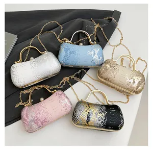 Detailed close-up of evening clutch bags with snake texture and pearl clasp closure