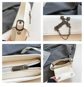 Detail view of cream PU crossbody bag with gothic metal cross charm and inner compartments