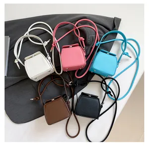 Detail of five colorful mini PU leather box bags with pebble texture and metal feet