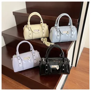 Detailed view of glossy patent leather pillow bags with heart lock and rivets in four colors