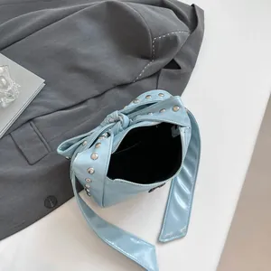 Light blue studded crossbody bag with metallic rivets and trendy knot strap detail