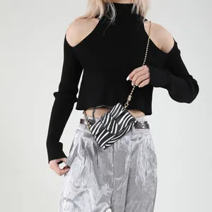 Chic zebra pattern mini crossbody bag with gold chain strap shown on a fashion model
