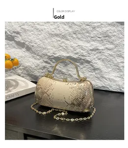 Detailed view of gold snakeskin textured clutch with elegant metal handle and chain