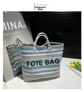 Gros plan sur le sac cabas tissé bleu iridescent avec lettrage brodé TOTE BAG en relief