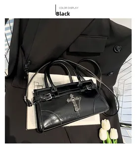 Detail of black glossy leather handbag featuring gothic cross and fine silver chain trim