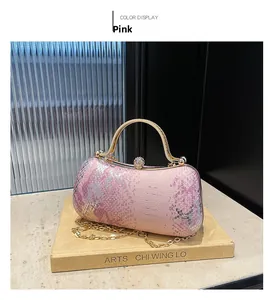 Detail of pink snakeskin texture box bag with gold metal handle and rhinestone clasp