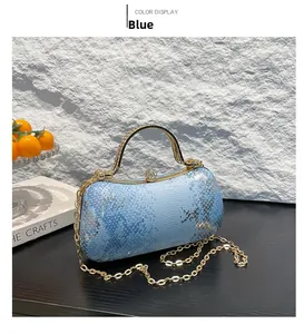 Macro detail of blue snakeskin evening bag with rhinestone handle and crystal ball clasp