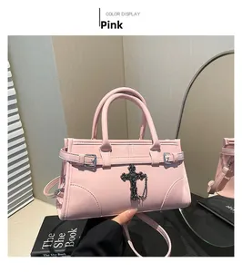 Detail of pink glossy leather tote with gothic black metal cross and chain ornament