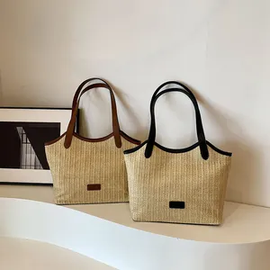 Grands sacs cabas tendance en paille tressée avec garnitures marron et noir sur socle