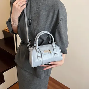 Chic light blue leather pillow handbag with rivet details and adjustable shoulder strap