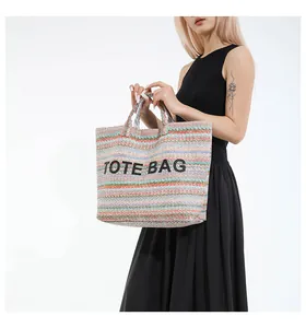 Détail du sac cabas tissé à rayures colorées avec broderie TOTE BAG sur le devant