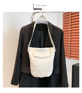 Détails d'un sac seau blanc avec rivets et sangle à œillets argentés
