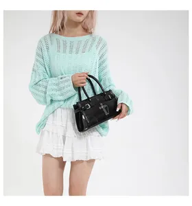 Chic black glossy handbag with silver cross charm styled with an elegant outfit