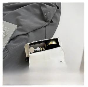Interior view of minimalist white handbag showing capacity for phone and cosmetics