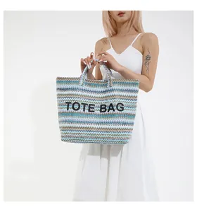 Détail d'un grand sac cabas tissé avec motifs ondulés bleus et beiges et texte Tote Bag