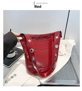 Détail du sac seau en cuir verni rouge avec rivets argentés et finition brillante