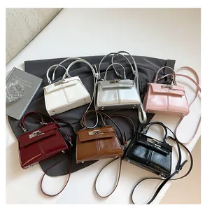 Detail view of colorful minimalist top-handle handbags with metal locks and bottom rivets