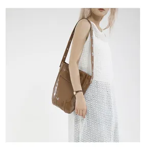 Dettaglio borsa a secchiello marrone vintage con borchie metalliche sulla tracolla