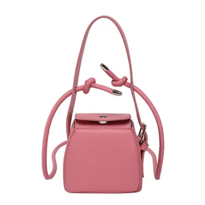 Pink minimalist PU leather trapezoid crossbody box bag with silver hardware on white background