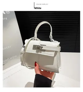 Detailed view of white mini square handbag with silver metal buckle and top handle