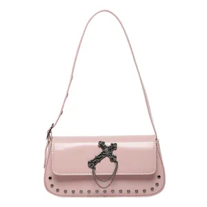 Pink patent leather square bag with vintage metal cross, chain, and studded details