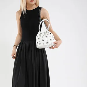 White bucket bag with silver studs, drawstring closure and chain strap for women
