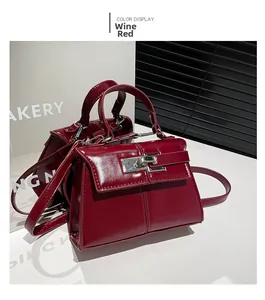Macro detail of wine red glossy patent leather handbag with silver metal rotary lock