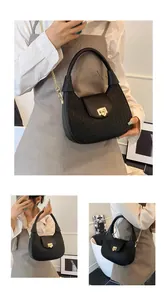 Detailed macro view of woven texture and gold metal buckle on black crescent handbag