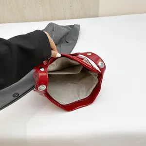 Borsa a secchiello in vernice rossa con rivetti argentati e ampio scomparto interno