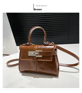 Detail view of brown glossy leather bag with silver metal turn-lock and handle