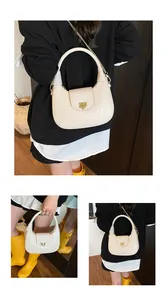 Detailed shot of cream woven hobo bag featuring gold H-buckle and metal chain strap