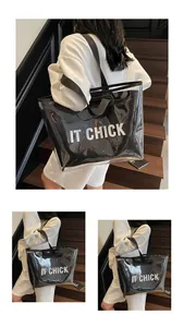 Detail of transparent PVC tote bag with white IT CHICK lettering and black shoulder strap