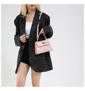 Detail view of pink trapezoid bag with metallic rotary lock and detachable strap