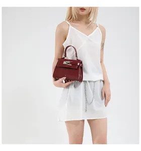 Burgundy shiny leather handbag featuring silver hardware and a classic trapezoid shape