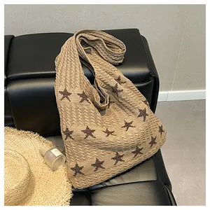 Detailed close-up of large knit tote bag with star pattern on a leather bench