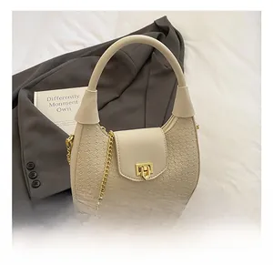 Detail of woven texture, gold metal lock, and chain strap on off-white crescent bag