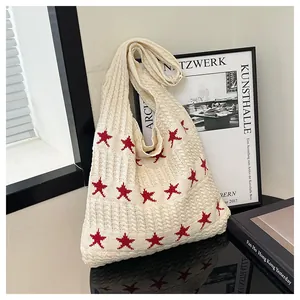 Detailed close-up of cream knitted tote bag featuring a red star pattern and thick knit texture