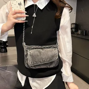 Retro grey denim crossbody bag with metal chain strap worn by a model in casual style