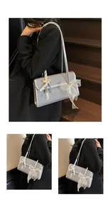 Close-up of light blue underarm bag with ribbon bow and wood grain texture detail