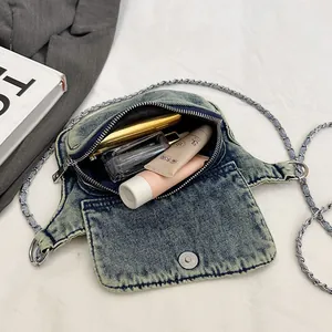 Vintage denim crossbody bag with silver chain strap and cosmetic storage demonstration