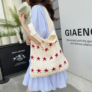 Chic cream knitted star pattern tote bag held by a model in casual striped shirt dress