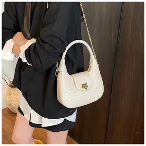 Detail of cream woven crescent handbag with gold chain strap and crocodile texture