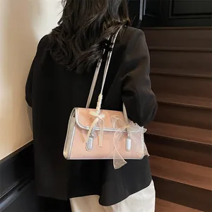 Pink trendy underarm bag with silver trim and elegant ribbon bow detail shown on a model