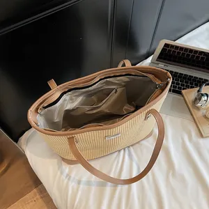Large woven straw tote bag with brown handles and a spacious inner zip pocket