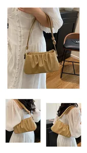 Detailed view of apricot ruched cloud bag showing soft leather texture and shoulder strap