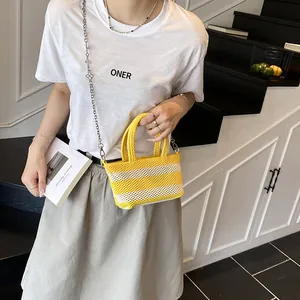 Striped knit mesh mini tote bag with silver chain strap shown on a model