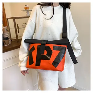 Detail of orange and black crossbody bag with KP7 lettering and buckle closure
