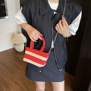 Striped red and white woven tote bag with round handles and silver chain shoulder strap