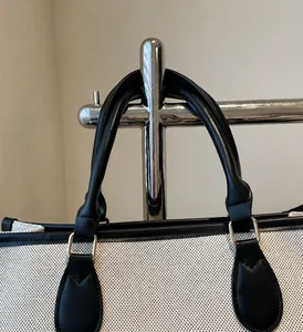 Λεπτομέρεια από ανθεκτικές μαύρες δερμάτινες λαβές και ενισχυμένες ραφές σε πάνινη τσάντα